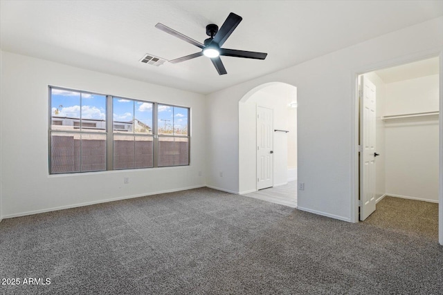 1510 W Fillmore St, Phoenix, AZ 85007 - unfurnished bedroom featuring arched walkways, carpet, a walk in closet, and ceiling fan