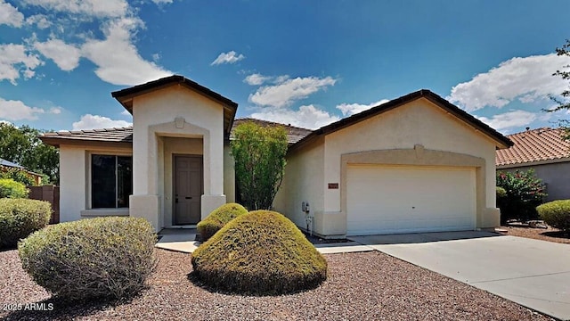 view of front of house featuring driveway, stucco siding, and a tiled roof