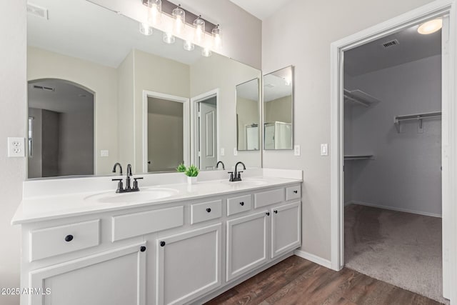 full bathroom featuring wood finished floors, a sink, and visible vents