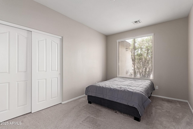 carpeted bedroom with baseboards, visible vents, and a closet