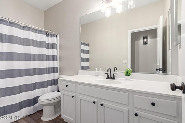 full bathroom featuring curtained shower, toilet, vanity, and wood finished floors