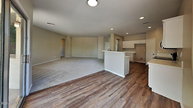 kitchen featuring range, visible vents, white cabinets, arched walkways, and dark wood-style flooring