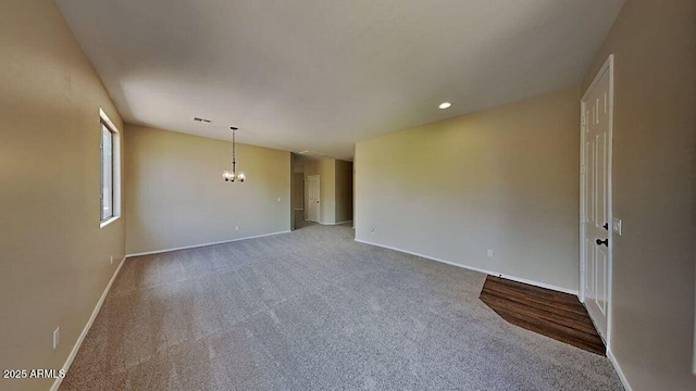 carpeted empty room featuring baseboards, a chandelier, and recessed lighting