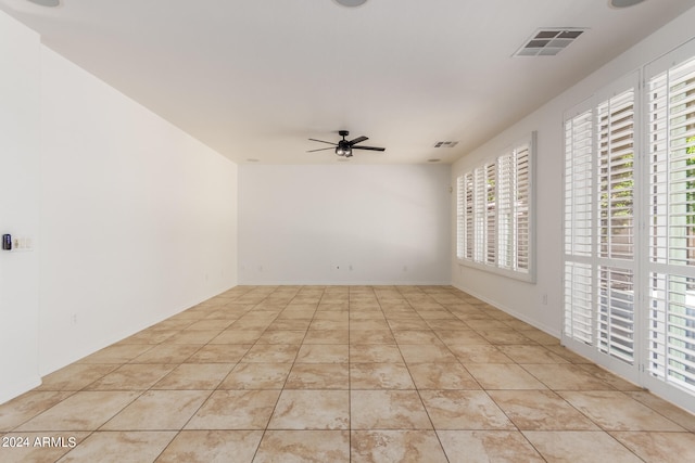 tiled empty room featuring a wealth of natural light and ceiling fan