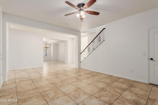 unfurnished room featuring ceiling fan with notable chandelier and light tile patterned floors