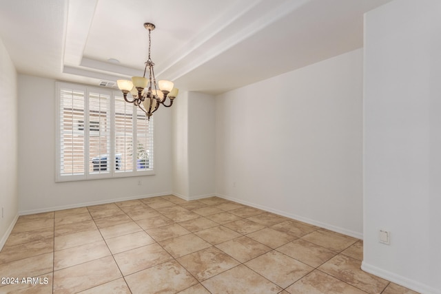 tiled empty room featuring a raised ceiling and an inviting chandelier