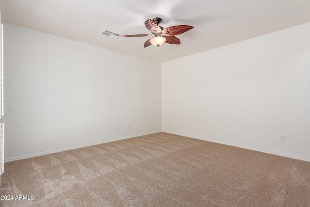 empty room with ceiling fan and light carpet