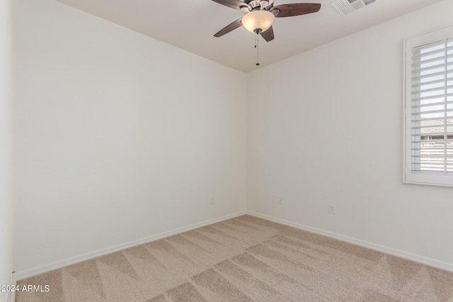 carpeted spare room featuring ceiling fan