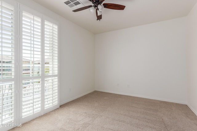 spare room featuring light colored carpet and ceiling fan