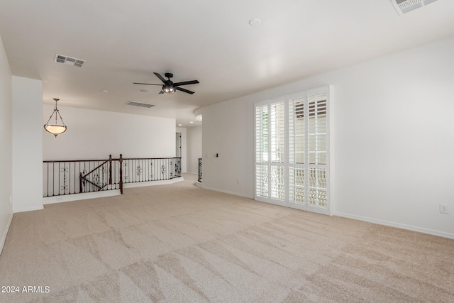 carpeted spare room with ceiling fan