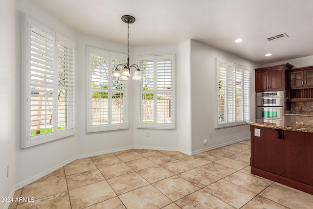 unfurnished dining area with a chandelier and light tile patterned flooring