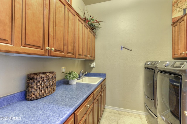 washroom with cabinets, independent washer and dryer, sink, and light tile patterned floors