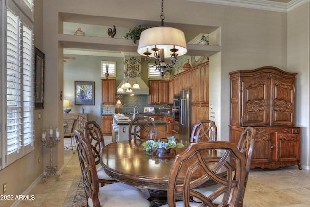 dining area with built in shelves, an inviting chandelier, crown molding, and sink