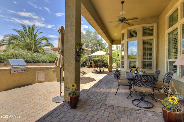 view of patio / terrace with ceiling fan, exterior kitchen, and a grill