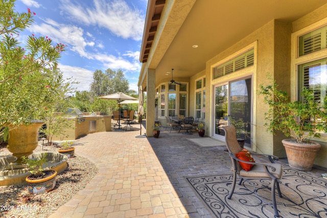 view of patio / terrace featuring ceiling fan and exterior kitchen