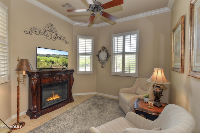 sitting room with ceiling fan, light tile patterned flooring, and ornamental molding