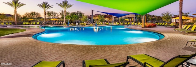 pool at dusk featuring a patio area