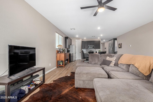 living room featuring ceiling fan and light wood-type flooring