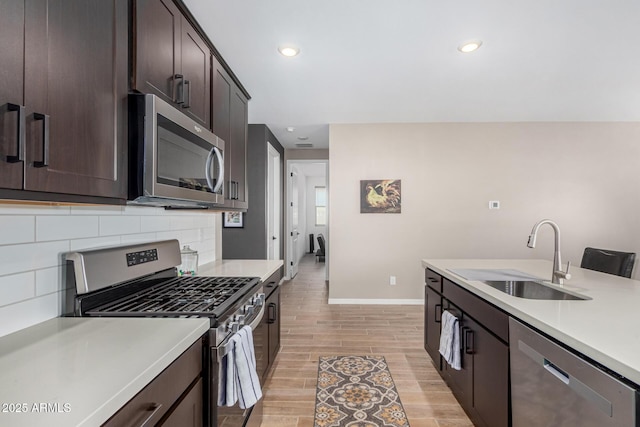 kitchen with tasteful backsplash, sink, stainless steel appliances, and dark brown cabinetry