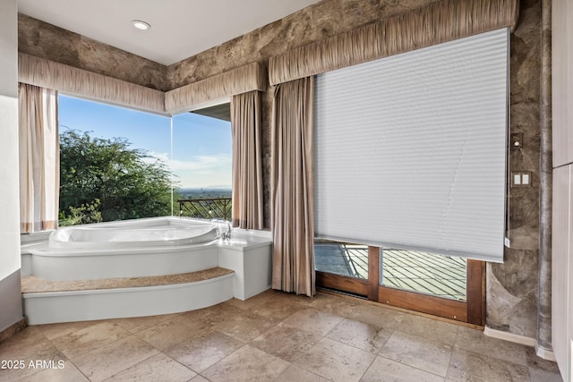 bathroom with plenty of natural light and a bathtub