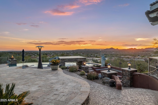 patio terrace at dusk featuring a mountain view