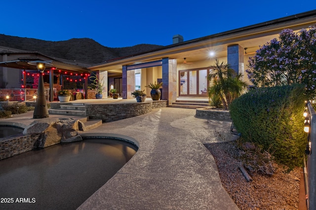 view of patio / terrace with french doors and a pool with hot tub