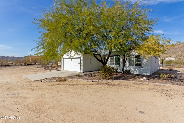 obstructed view of property with a mountain view and a garage