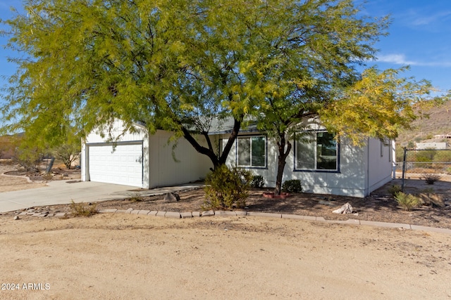 view of property hidden behind natural elements with a garage