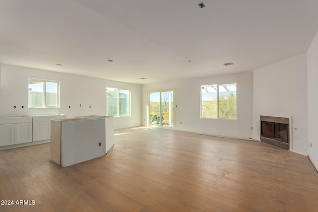 unfurnished living room with a wealth of natural light and light hardwood / wood-style floors