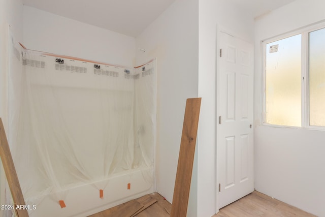 bathroom featuring wood-type flooring and tub / shower combination