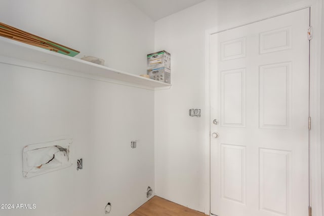 clothes washing area with wood-type flooring