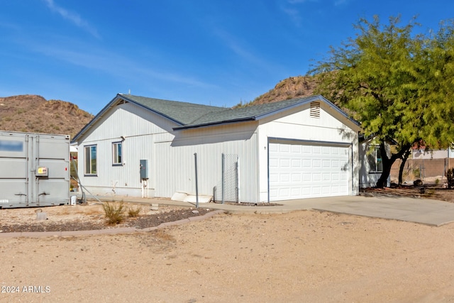 view of side of property with a mountain view and a garage