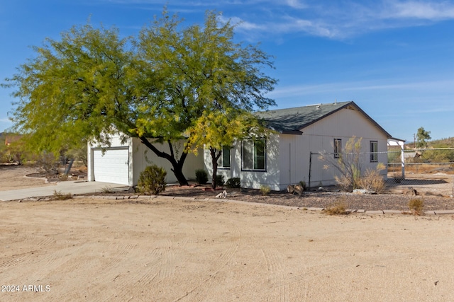 view of property hidden behind natural elements with a garage