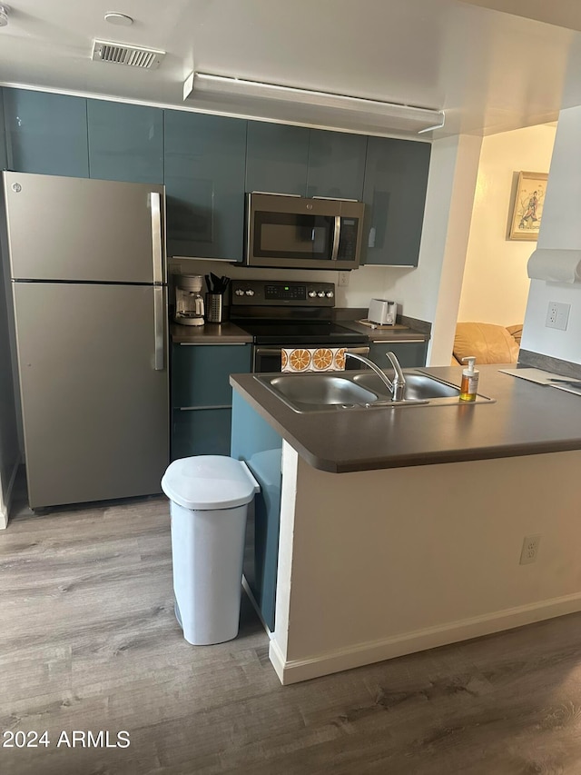 kitchen featuring light hardwood / wood-style flooring, white refrigerator, electric range oven, sink, and kitchen peninsula