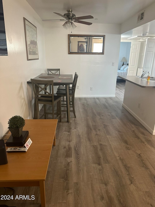 dining area featuring sink, dark wood-type flooring, and ceiling fan