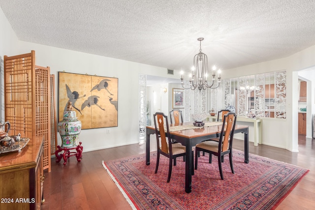 dining room with dark hardwood / wood-style flooring, an inviting chandelier, and a textured ceiling