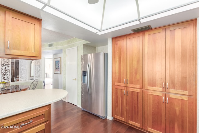 kitchen with dark hardwood / wood-style flooring and stainless steel fridge