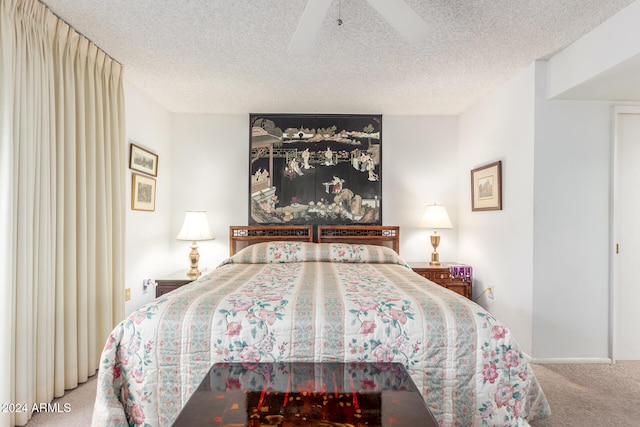 carpeted bedroom featuring ceiling fan and a textured ceiling