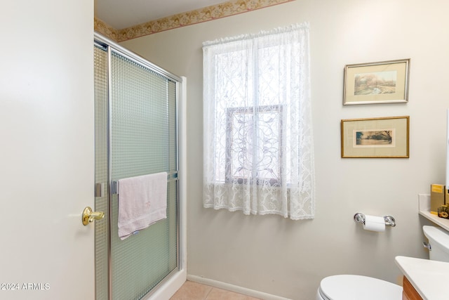 bathroom featuring vanity, a shower with shower door, tile patterned floors, and toilet