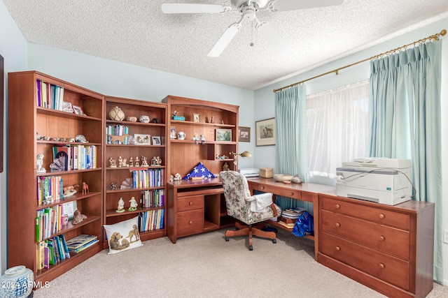 office featuring ceiling fan, a textured ceiling, and light carpet