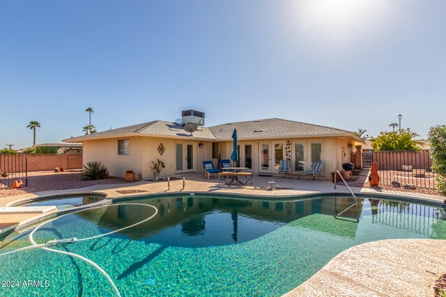 view of swimming pool featuring an in ground hot tub, french doors, and a patio area