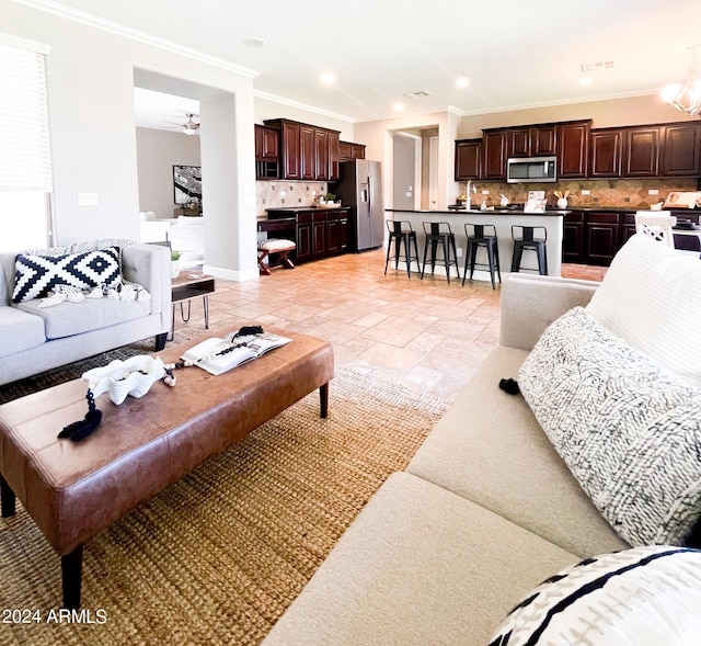 living room featuring crown molding, ceiling fan, and sink