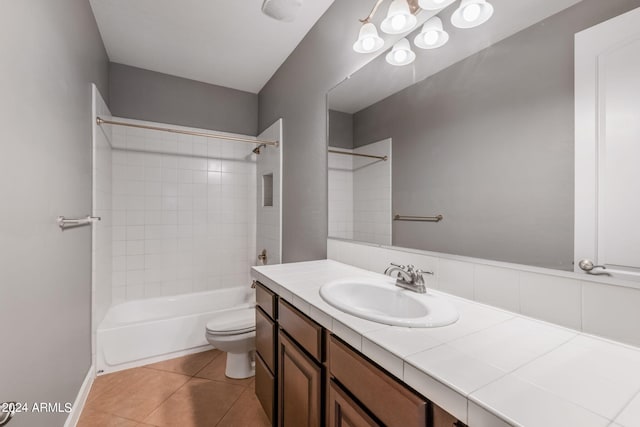 full bathroom with tiled shower / bath, vanity, tile patterned floors, and toilet