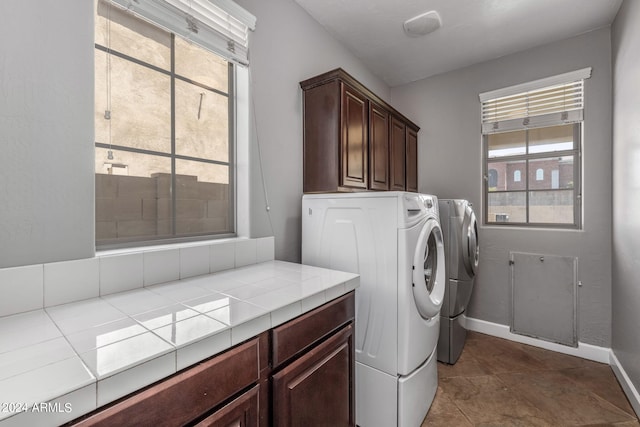 laundry room featuring separate washer and dryer and cabinets