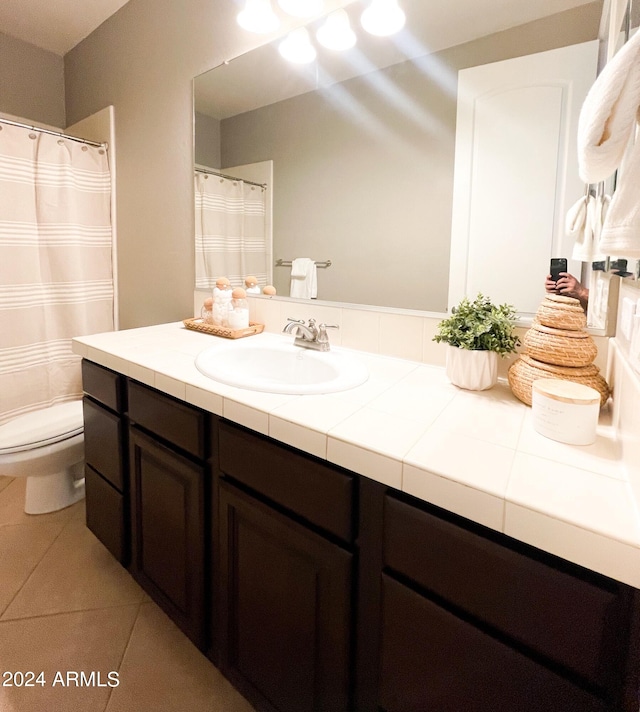 bathroom featuring vanity, tile patterned floors, and toilet