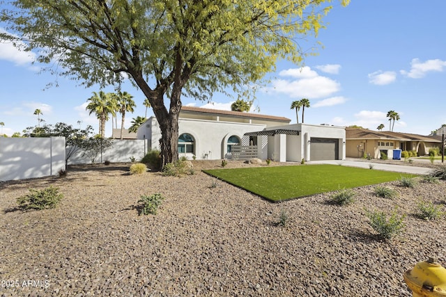 back of house featuring concrete driveway, an attached garage, fence, a yard, and stucco siding