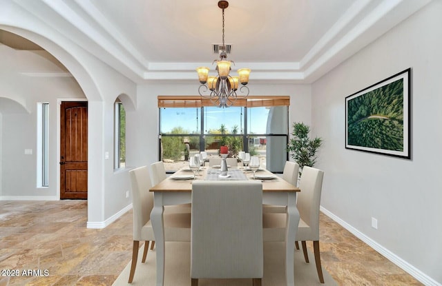 dining room featuring a tray ceiling and a chandelier