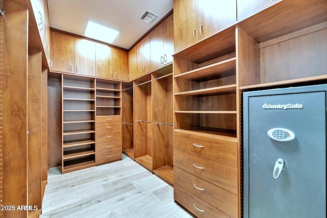 walk in closet with light hardwood / wood-style floors