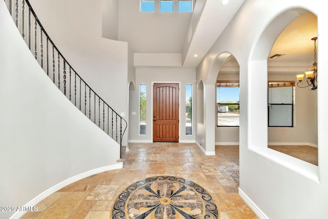 entryway featuring a notable chandelier and a towering ceiling