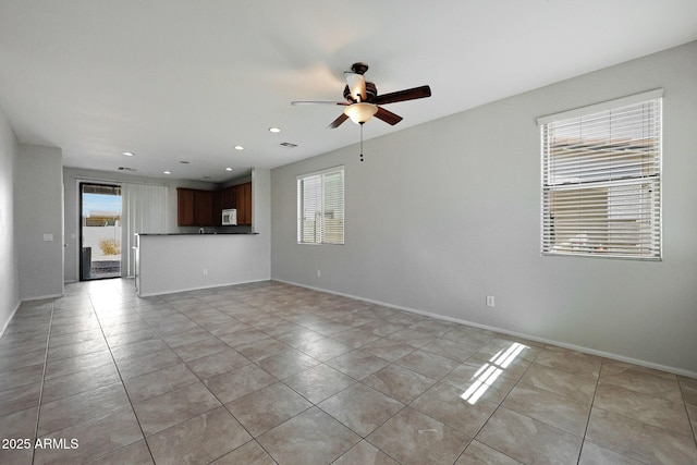 unfurnished living room featuring ceiling fan and light tile patterned flooring